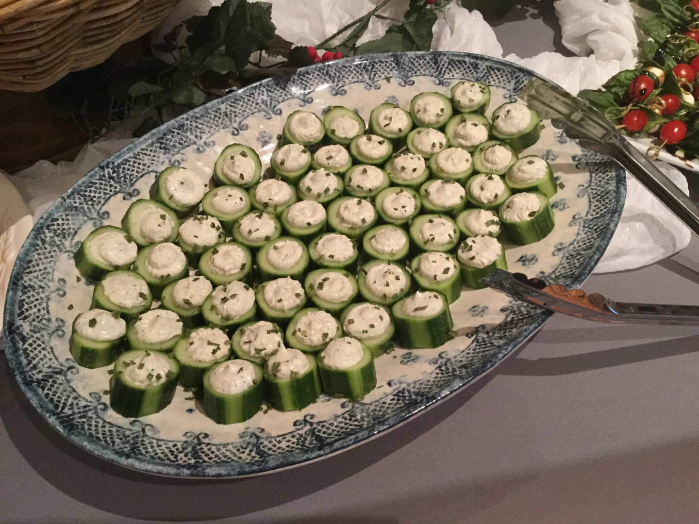 A platter of cucumber slices with cheese on top.