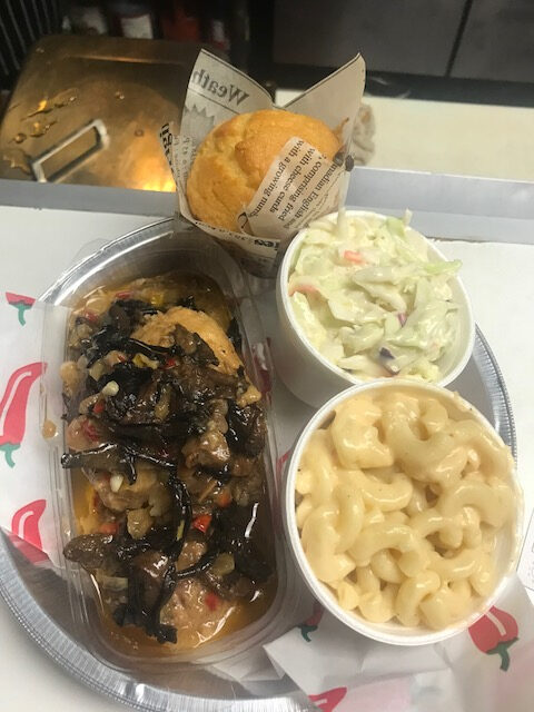 A plate of food with macaroni and cheese, cole slaw and ribs.